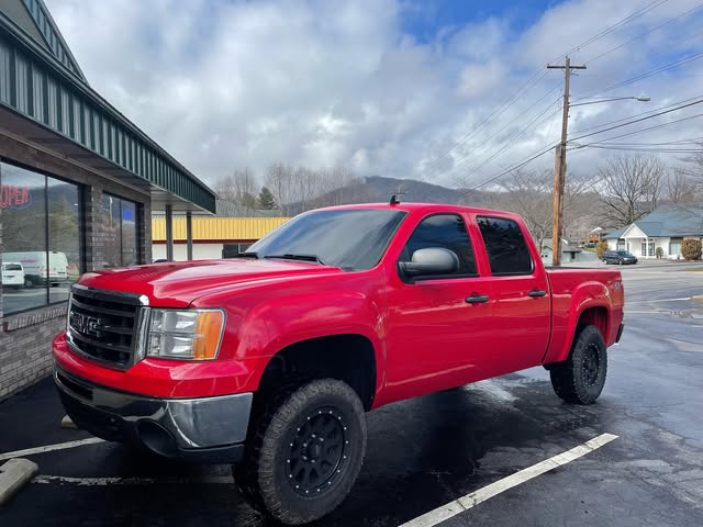 Red GMC pickup with dark window tint in the mountains
